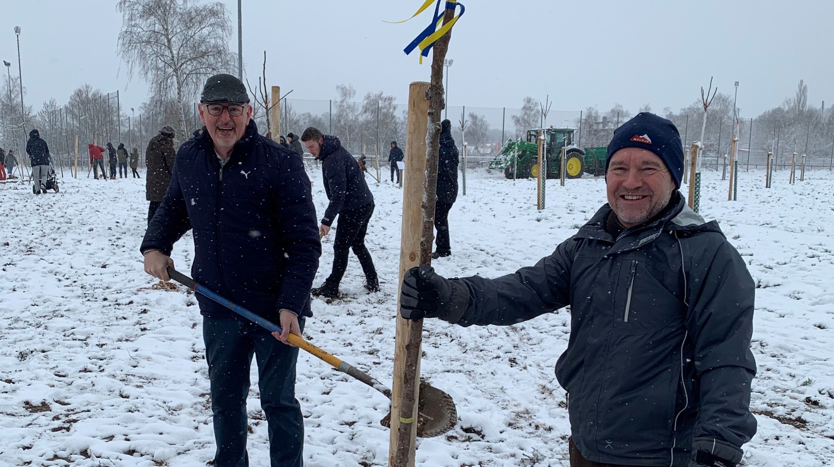 Das Bild zeigt Bürgermeister Thomas Zwingel und den Leiter der Service-Betriebe Ralf Klein bei einer Baumpflanzung im Schnee.