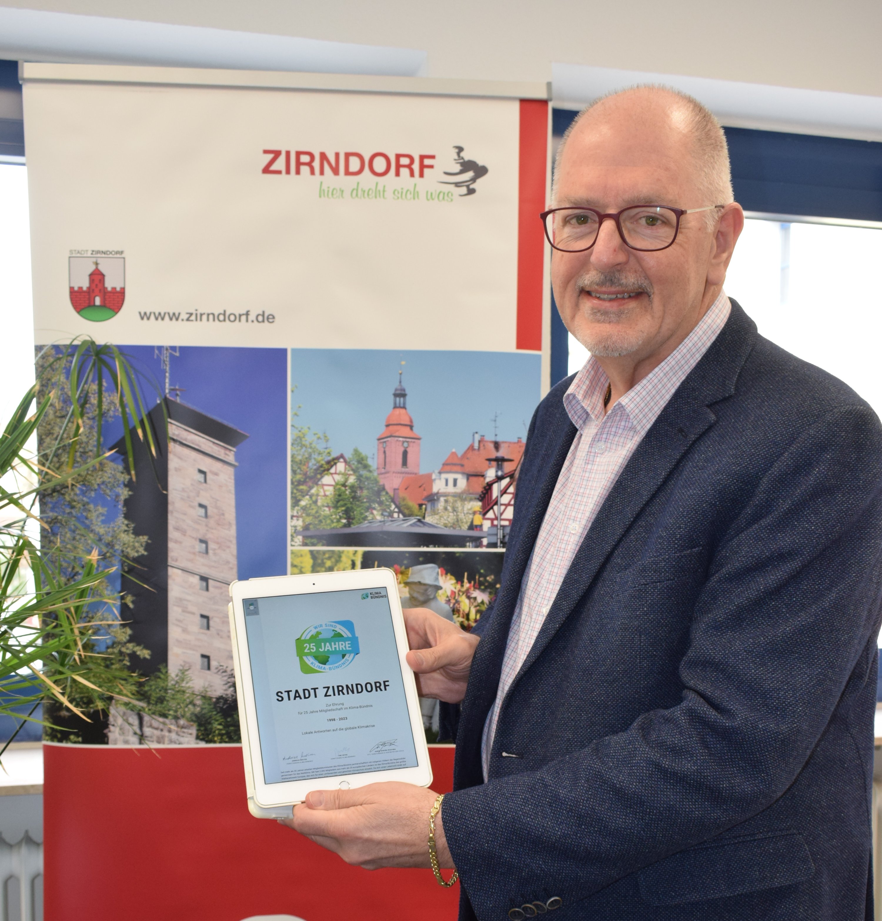 Das Bild zeigt Bürgermeister Thomas Zwingel mit der digitalen Urkunde.